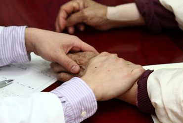 해운대자생한방병원 자생치료의 특징-환자 손을 잡아 건강상태를 체크 하고 있는 의사의 모습